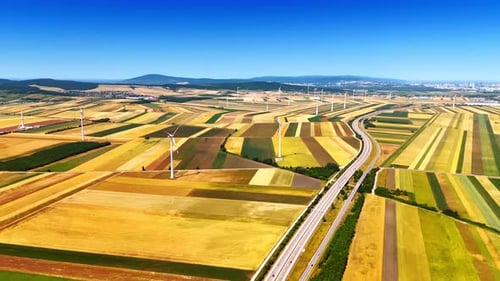 Beautiful vast agricultural fields of colorful patches crossed by the highway.