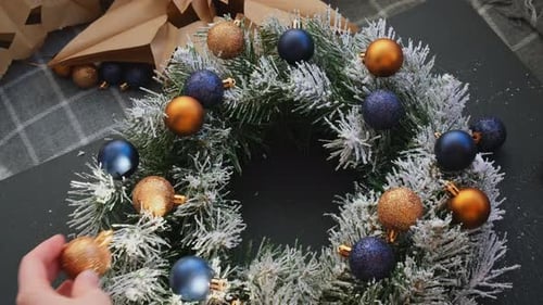 Christmas Decorations Being Glued onto a Wreath