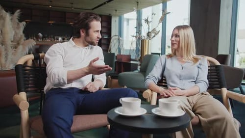 In Cafe Young Couple Sitting Talking Man and Woman Have Conversation Portrait Close Up Slow Motion