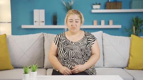 Blonde Woman Sitting on Grey Couch Indoors