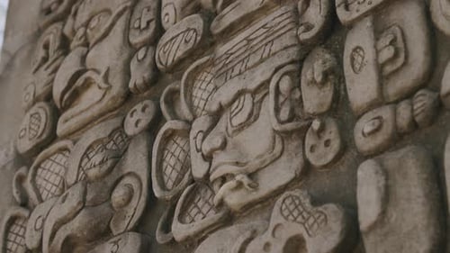 Footage that is close to of an ancient Mayan artifact with symbols carved into the front of it.