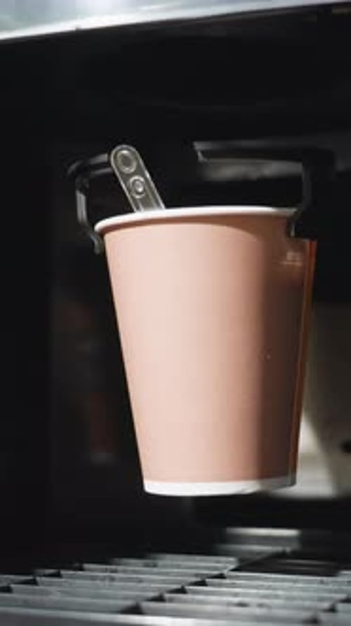 Coffee Being Dispensed into Paper Cup in Machine