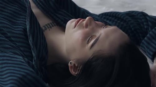 Female in Sleepwear Laying on the Bed in the Studio Young Woman in Pajama Shirt Laying Posing Under