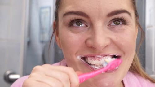 Woman Brushing Teeth in Bright Bathroom Close Up