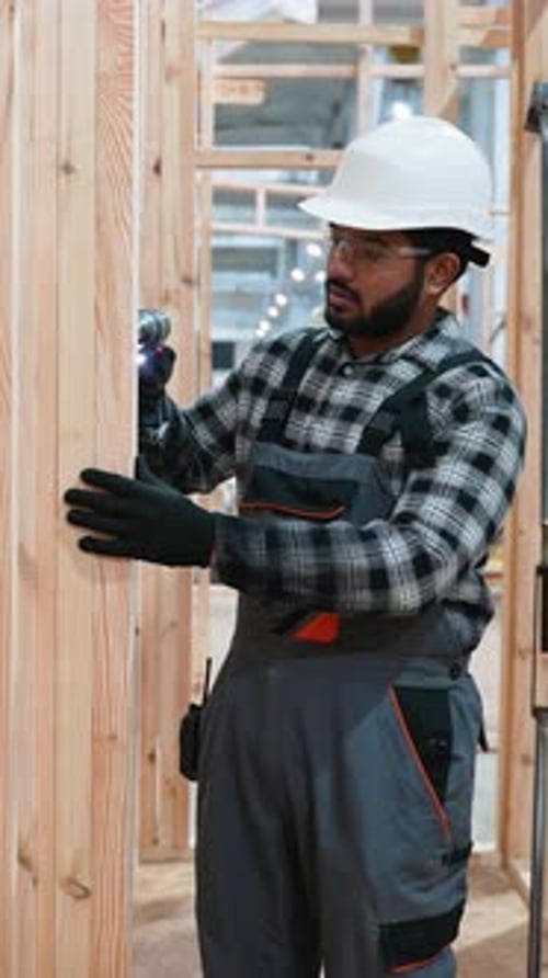 Carpintero ensamblando marcos de madera en una fábrica de casas modulares