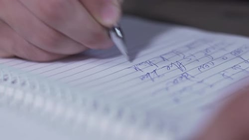 a close up shot of a man writing on paper with pen - 4K