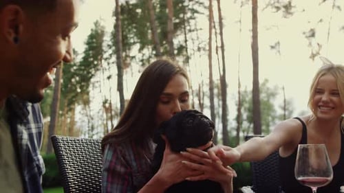 Friends Enjoying Outdoor Meal with Pet Pug