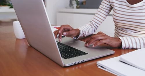 Woman Typing on Laptop at Home