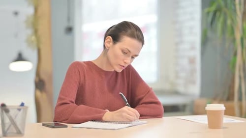 Beautiful Woman Writing Letter in Office