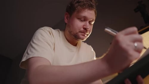 Nachdenklicher junger Illustrator erlebt eine kreative Krise, hält nachdenklich inne und reibt sich das Gesicht