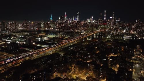 Aerial View Capturing Lively Movement of Vehicles on Queensboro Bridge Directing Towards Glowing