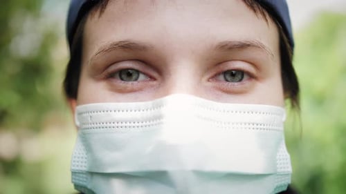 Medical Woman Removing Surgical Mask and Smiling