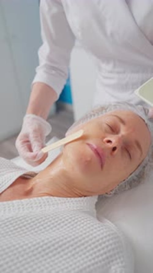Woman Getting Fractional Microneedle RF Face Lifting Procedure in Beauty Salon