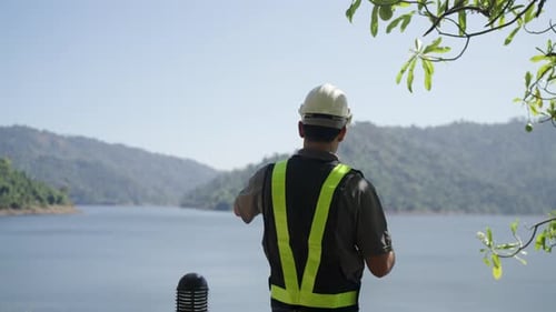 Blue collar worker is working at the dam.
