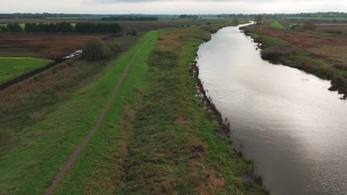 Aerial view of Ely's winding river amidst tranquil countryside fields and grass paths