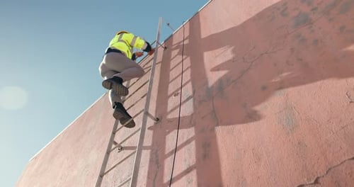 Man on Ladder Climbing Tall Building
