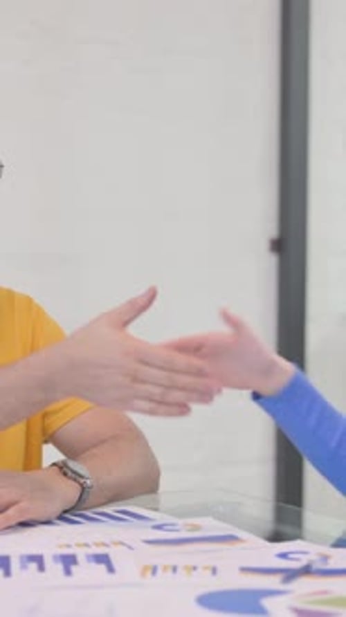 Business Handshake Between Man and Woman at Desk
