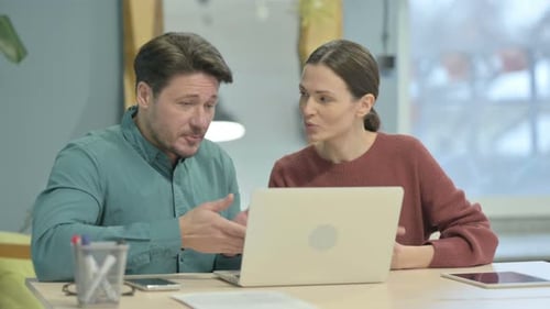 Man and Woman Video Conferencing on Laptop