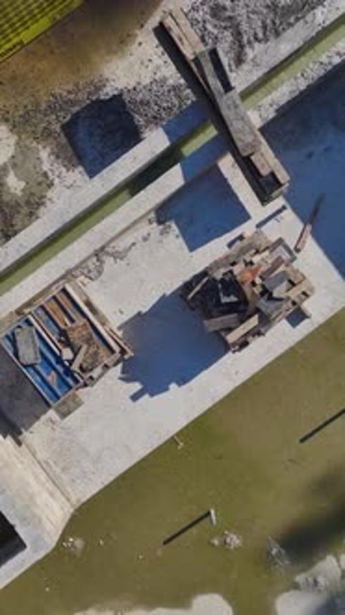 Vertical Video of a Construction Crew Installing Steel Beams for the Framework of a New House