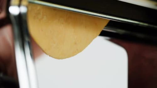Woman Using Pasta Machine to Make Fresh Pasta Dough in the Kitchen Cooking in Italian Restaurant