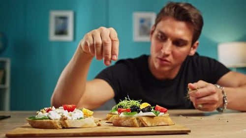 Young Man Decorates Open Faced Berry Sandwich
