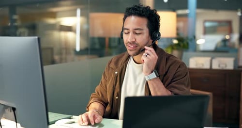 Young man at desk wearing headset working