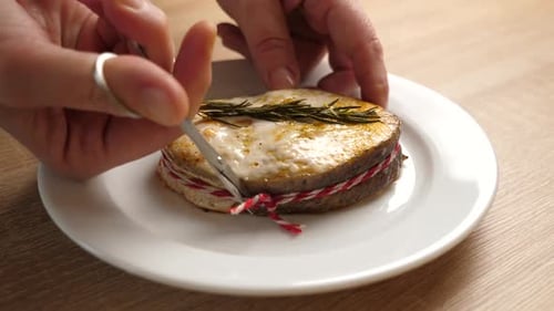 15sm. A freshly baked piece of salmon is placed on a plate. Slow motion.