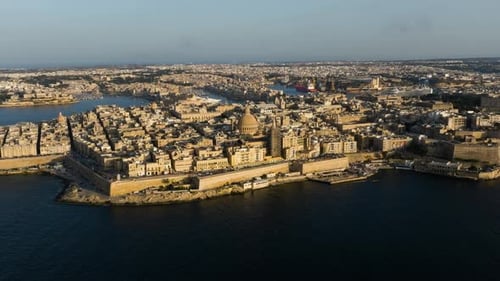 Aerial view flying around the cityscape of Valletta, dramatic sunset in Malta
