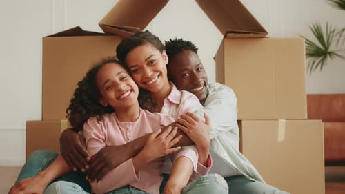 Die umziehende Familie genießt einen schönen Moment in einer neuen Wohnung mit Umzugskartons