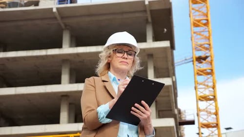 Entrepreneur Makes Notes on Clipboard of Building Processes