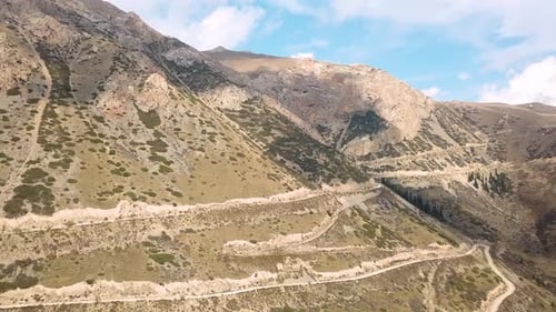 Vue aérienne d'une voiture roulant sur un chemin de terre de montagne
