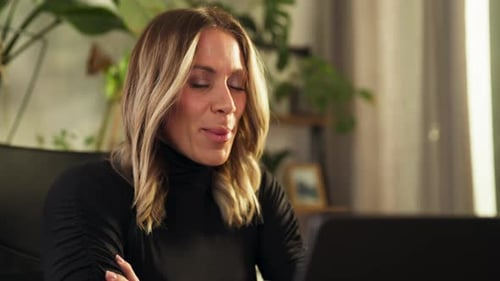 Woman Smiling at Computer and Talking Indoors