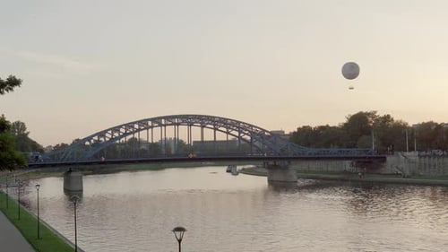 Iron Bridge and Hot Air Balloon Over Vistula River at Sunset in Krakow