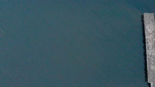 4k Aerial Top Down Reveal Panning shot from Left to Right of a Shipping Port Pier on a Sunrise with