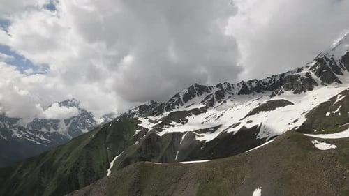 Aerial View of Caucasus Mountains in Svaneti with Snowcapped Peaks Green Valleys Lone Figure on