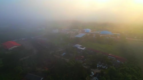 Drone flying in the fog over a rural village