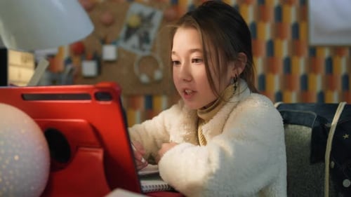 Girl Studying with Tablet and Writing in Notebook