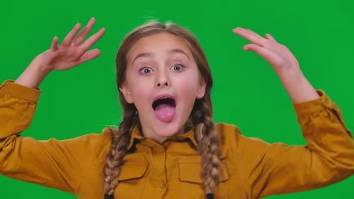 Carefree Girl Making Faces Having Fun on Green Screen Looking at Camera Closeup Portrait of Relaxed