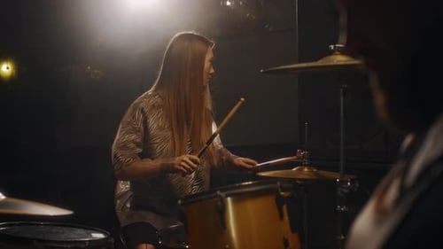 Woman Plays Drums During a Concert
