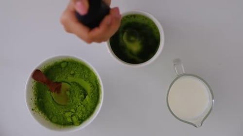 Woman Cooks at Home Matcha Tee Slowmotion of Mixing Matcha Tee Late with Electric Blender Mixed in