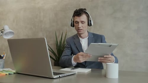 Man in Suit Presenting Data Online via Laptop