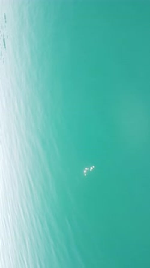 Vertical Aerial View on Sea Water Surface Camera Flies Over Clear Sea Water Sun Glare Abstract