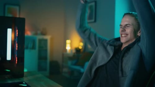 Excited young man plays video game in his room