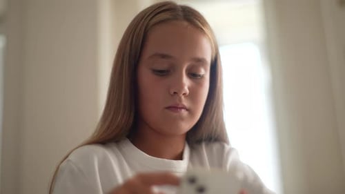 Girl Using Mobile Phone Indoors, Close Up