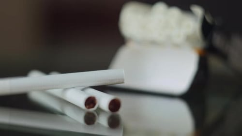 An Open Pack of Cigarettes with Cigarettes on the Table The Focus Shifts From the Pack to the