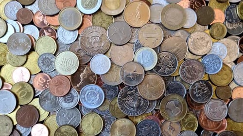 A background of silver, gold, and copper coins of various denominations. Metal coins