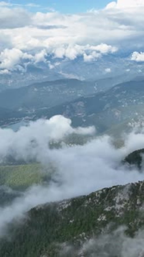 Vertical Video Aerial View of Mountain Landscape with Clouds Majestic Peaks and Ethereal Skies
