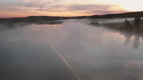 fly over lake covered in fog and reflection of clouds in the morning with dji drone mavic 2