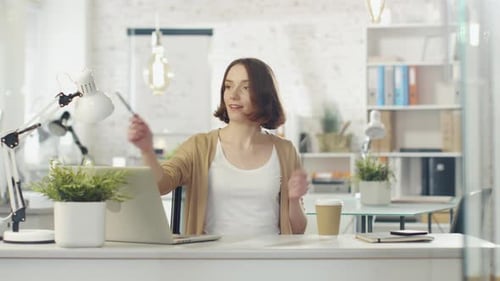 Creative Young Woman Sits at Her Working Place and Plays With Pencils as if They are Imaginary Musi