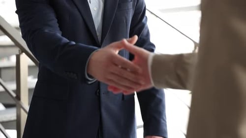 Businessmen Shake Hands in Modern Office Building